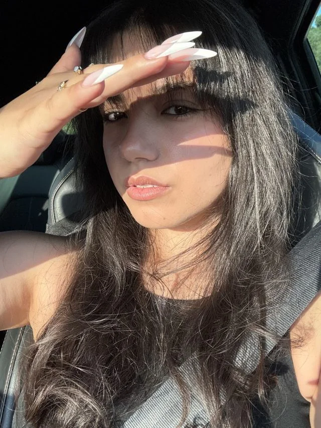 Jana Ceylan im Auto, die Hand schützend über den Augen